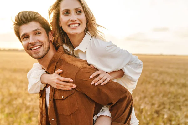 Image Young Caucasian Beautiful Couple Doing Piggyback Ride Golden Field — Stock Photo, Image