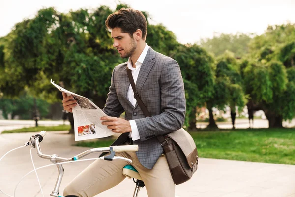 Parkta Bisiklet Üzerinde Gazete Okuyan Yakışıklı Konsantre Bir Adamının Görüntüsü — Stok fotoğraf