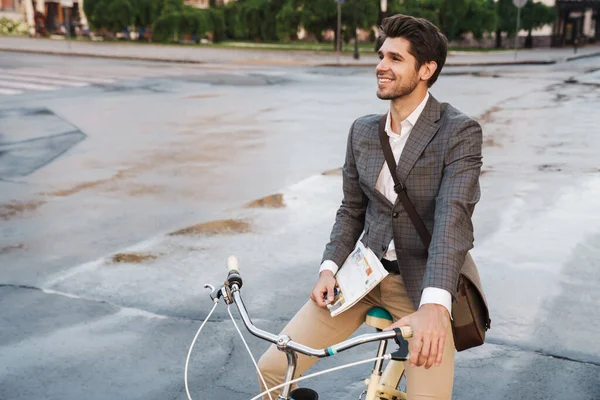 幸せなハンサムなビジネスマンのイメージのジャケット笑顔と市内通りで自転車に新聞を保持 — ストック写真