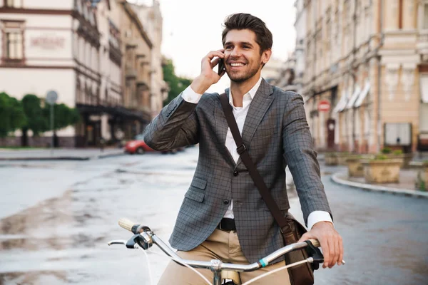 야외에서 자전거를 핸드폰으로 이야기하는 잘생긴 낙천적 사업가의 — 스톡 사진
