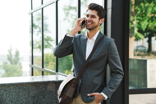 在商务中心附近 一个乐观的 快乐的 英俊的商人在户外用手机交谈的形象 — 图库照片
