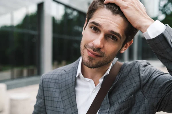 İş merkezinin yakınındaki açık havada iyimser yakışıklı iş adamının görüntüsü