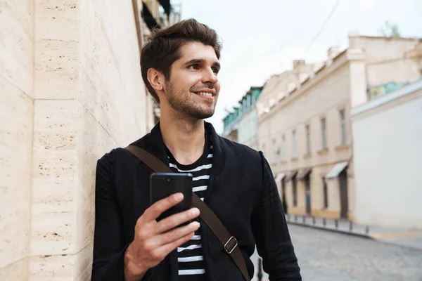 Imagen Hombre Guapo Feliz Sonriendo Usando Teléfono Celular Mientras Apoya — Foto de Stock