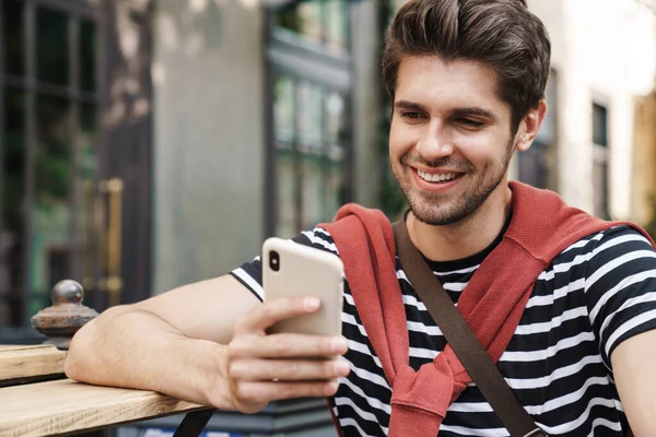 Imagen Hombre Guapo Alegre Sonriendo Usando Teléfono Celular Mientras Camina — Foto de Stock