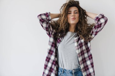 Beyaz arka planda izole bir şekilde kamerada poz veren mutlu, güzel bir kadının fotoğrafı.