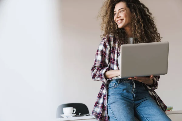 Foto Hermosa Mujer Alegre Sonriendo Usando Ordenador Portátil Mientras Está —  Fotos de Stock