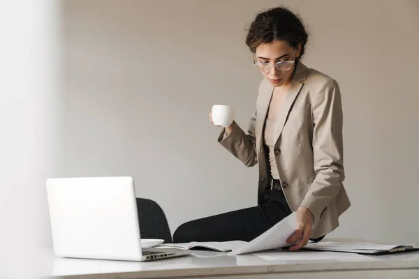 Kuva Keskittynyt Brunette Nainen Silmälasit Kahvin Juominen Työskennellessään Kannettavan Tietokoneen — kuvapankkivalokuva