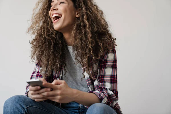 Foto Mulher Bonita Animado Rindo Usando Celular Enquanto Sentado Isolado — Fotografia de Stock