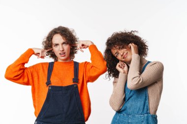 Tulum giymiş, beyaz arka planda kulaklarını tıkayan çok uluslu güzel kadınların portresi.