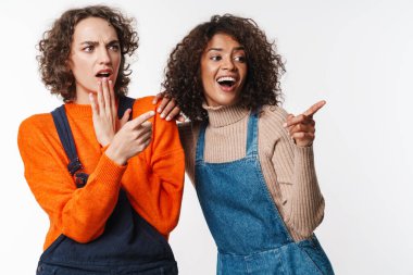 Tulumlu çok uluslu kadınların beyaz arka planda izole edilmiş parmaklarını gösteren portresi.