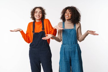 Tulum giymiş çok uluslu güzel kadınların portresi kameraya bakıyor ve beyaz arka planda izole edilmiş elleri kusuyor.