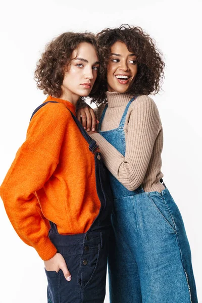 Tulum giymiş, kameraya bakıp beyaz arka planda izole edilmiş bir şekilde sarılan çok uluslu güzel kadınların portresi.