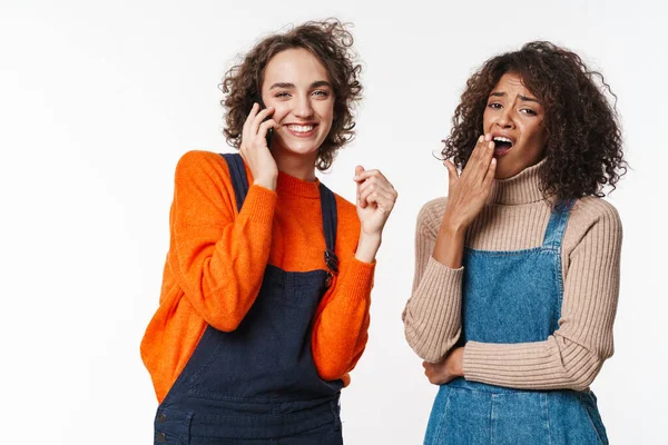 Beyaz arka planda izole edilmiş cep telefonu kullanan çok uluslu güzel kadınların portresi.