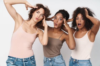 Beyaz arka planda soyutlanmış kafalarını tutan üç genç kadının portresi.