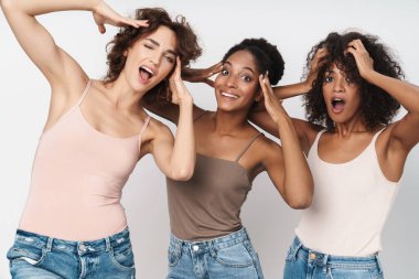 Beyaz arka planda izole edilmiş kafalarını tutan üç duygusal çoklu etnik kadının portresi