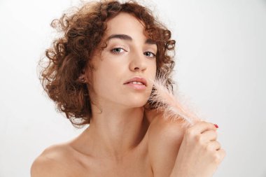 Beyaz arka planda izole edilmiş kısa kıvırcık kahverengi saçlı, tüylü, çekici, üstsüz bir kadının güzel portresi.