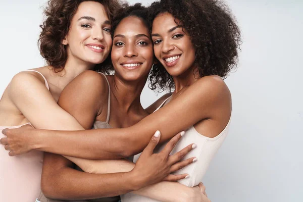 3人の可愛い多民族の女性の肖像画笑顔と抱擁一緒に白い背景に隔離された — ストック写真