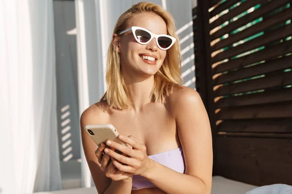 Imagem Mulher Feliz Sedutora Óculos Sol Sorrindo Usando Celular Hotel — Fotografia de Stock