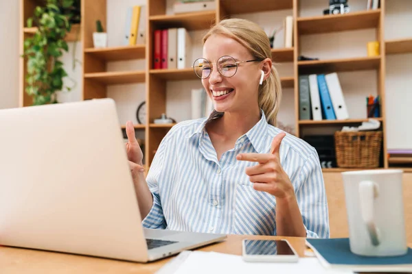 Imagem Uma Jovem Alegre Usando Fones Ouvido Sem Fio Apontando — Fotografia de Stock