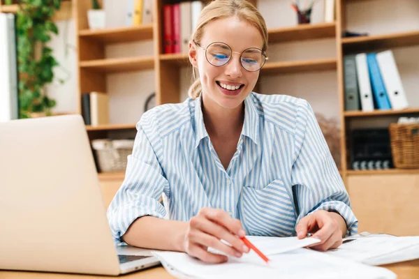 Imagem Mulher Loira Alegre Escrevendo Notas Sorrindo Enquanto Trabalhava Com — Fotografia de Stock