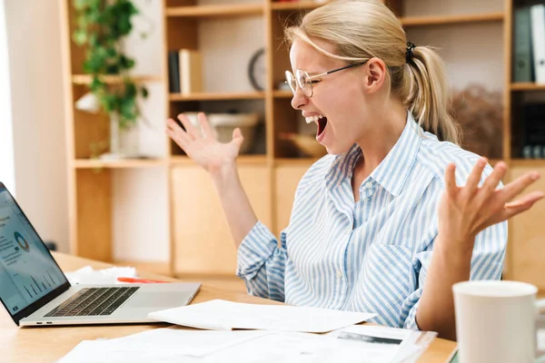 Image Displeased Blonde Woman Screaming While Working Papers Laptop Table — Stock Photo, Image