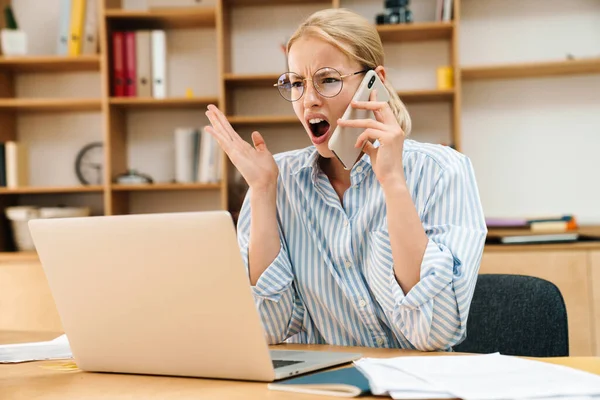 Obraz Wściekłej Atrakcyjnej Bizneswoman Rozmawiającej Przez Telefon Komórkowy Podczas Pracy — Zdjęcie stockowe