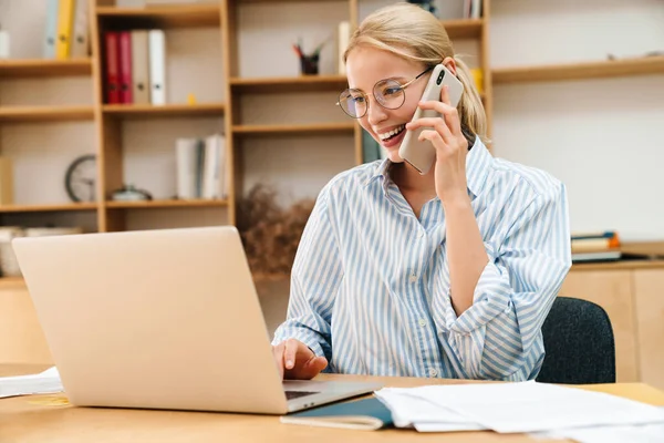 Obrázek Radostné Atraktivní Podnikatelky Mluvící Mobilním Telefonu Při Práci Notebookem — Stock fotografie