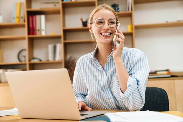 Imagem Empresária Atraente Alegre Falando Celular Enquanto Trabalhava Com Laptop — Fotografia de Stock