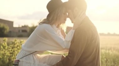 Güzel bir çift, kırsalda bisiklet sürerken birbirlerine sarılıyorlar.