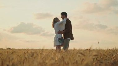 Romantik çift, kırsalda yürürken birbirlerine sarılıyorlar.