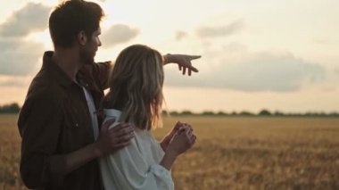 Rüya gören güzel bir çift. Erkek ve kadın yürürken ve tarlada bir yeri işaret ederken konuşuyorlar.