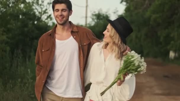 美しいカップルの男と女が田舎を歩いている — ストック動画