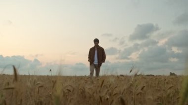 Yakışıklı genç bir adam yaz zamanı sahada yürüyor.