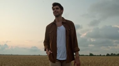 Yakışıklı genç bir adam yaz zamanı sahada yürüyor.