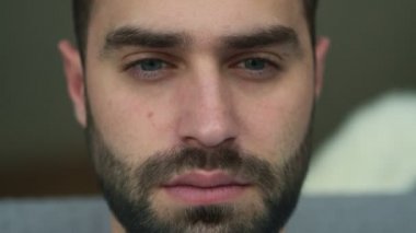 Evde oturup dizüstü bilgisayar kullanan yakışıklı, ciddi bir adamın yakın çekim videosu.