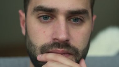 Evde oturan ve dizüstü bilgisayar kullanan genç bir adamın yakın çekim videosu.