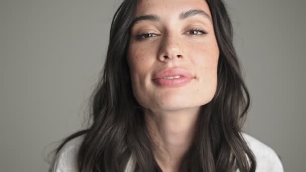Piękna Młoda Kobieta Wysyła Pocałunek Powietrza Kamery Stojącej Szarym Tle — Wideo stockowe