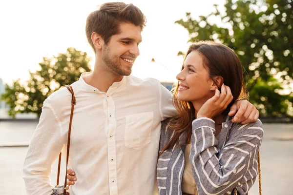 Imagem Jovem Casal Caucasiano Sorrindo Abraçando Enquanto Caminhava Com Câmera — Fotografia de Stock