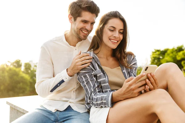 Image Young Caucasian Happy Couple Smiling Hugging While Sitting Outdoors — Stock Photo, Image