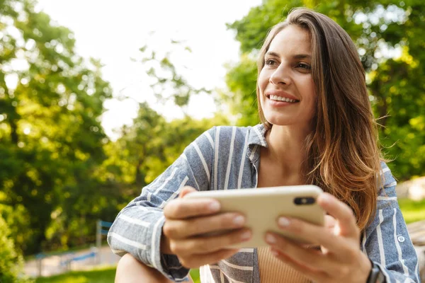 Imagem Jovem Mulher Morena Caucasiana Sorrindo Segurando Celular Enquanto Caminha — Fotografia de Stock