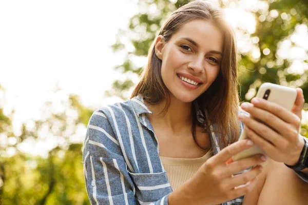 Imagem Jovem Mulher Morena Caucasiana Sorrindo Segurando Celular Enquanto Caminha — Fotografia de Stock