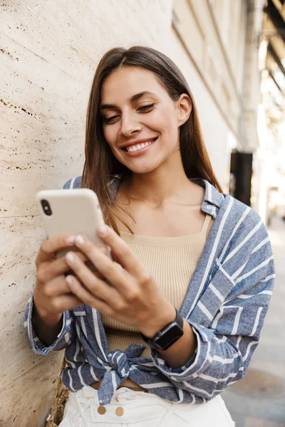 Imagem Jovem Mulher Morena Caucasiana Sorrindo Segurando Celular Enquanto Caminhava — Fotografia de Stock