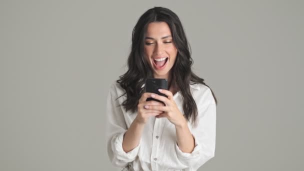 Uma Jovem Mulher Sorridente Está Usando Seu Smartphone Isolado Sobre — Vídeo de Stock