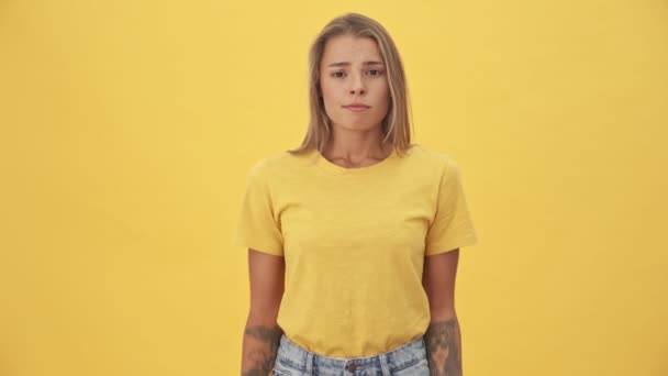 Una Atractiva Joven Rubia Con Camiseta Amarilla Encoge Hombros Pie — Vídeo de stock
