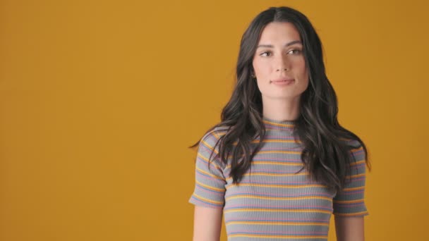 Překvapená Mladá Žena Ukazuje Volný Prostor Stojící Izolovaně Nad Žlutým — Stock video