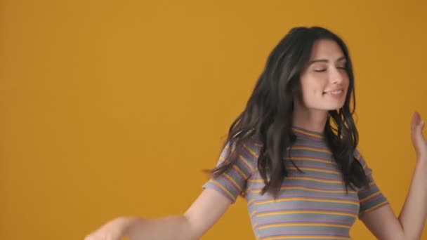 Una Joven Feliz Baila Aislada Sobre Fondo Amarillo — Vídeo de stock