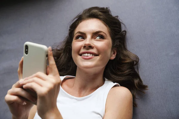 Зображення Красивої Веселої Жінки Яка Посміхається Використовує Мобільний Телефон Лежачи — стокове фото