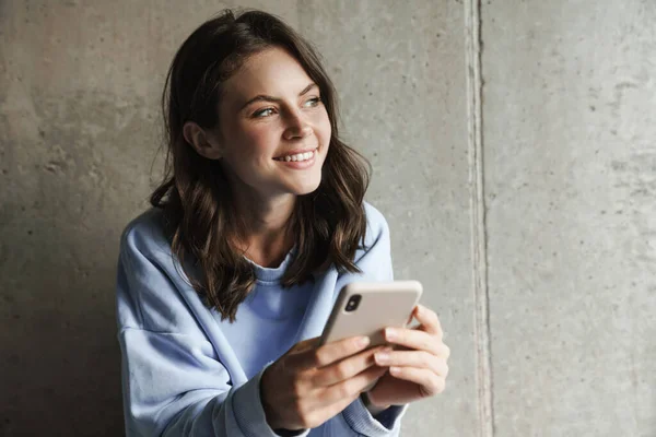 Imagen Mujer Alegre Morena Sonriendo Usando Teléfono Inteligente Mientras Descansa —  Fotos de Stock