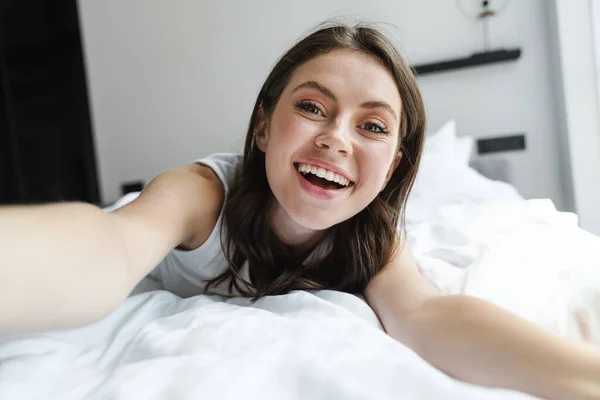 Evde Yatakta Yatarken Gülümseyen Selfie Çeken Büyüleyici Mutlu Kadın Görüntüsü — Stok fotoğraf