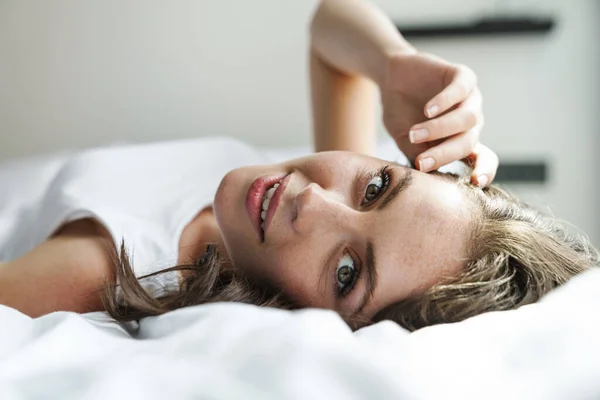 Evde Yatakta Yatarken Gülümseyen Kameraya Bakan Güzel Mutlu Kadın Görüntüsü — Stok fotoğraf